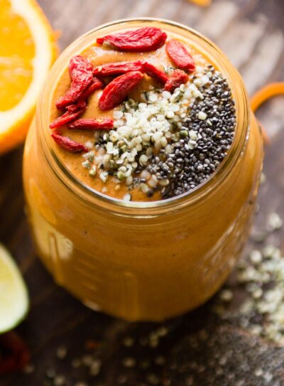 Orange superfood smoothie in a glass jar.