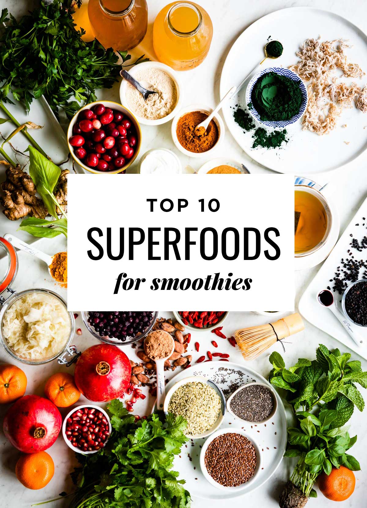 black text in white box saying Top 10 Superfoods For Smoothies overtop a counter full of various superfoods.