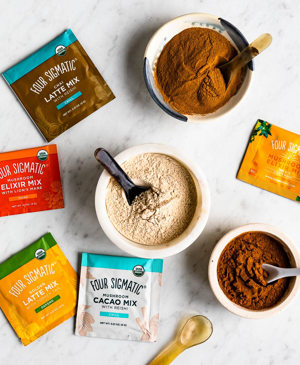 superfood adaptogens in bowls next to packets of Four Sigmatic products.