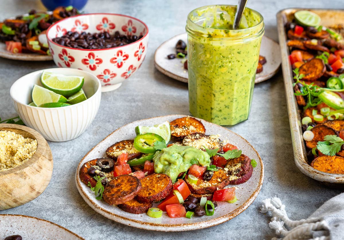 plate of homemade nachos topped with avocado crema.