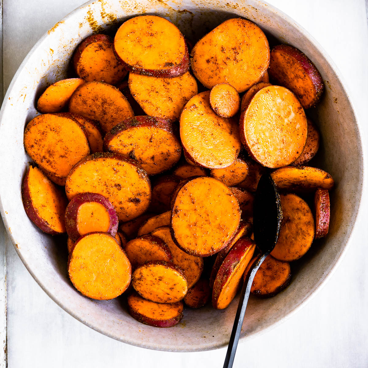 covering sweet potatoes with oil and spices