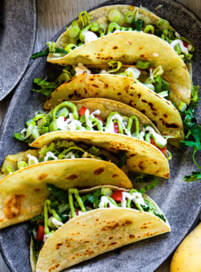 5 Tacos de papa or crispy potato tacos on an oval, gray plate.