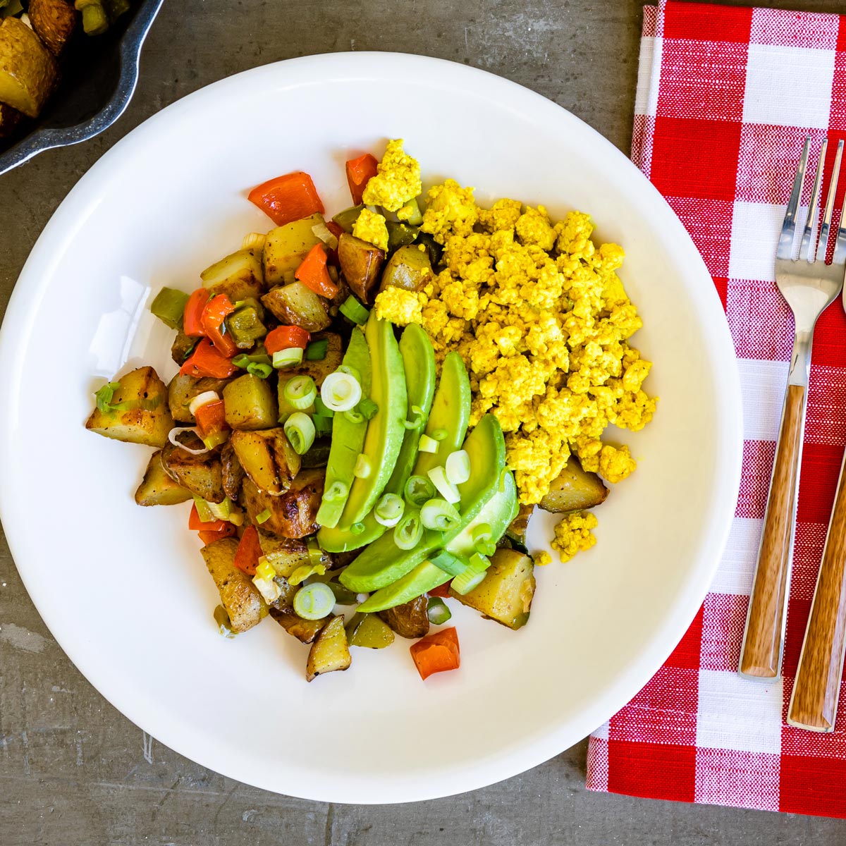 Tofu breakfast bowl recipe on a white plate with a red napkin.