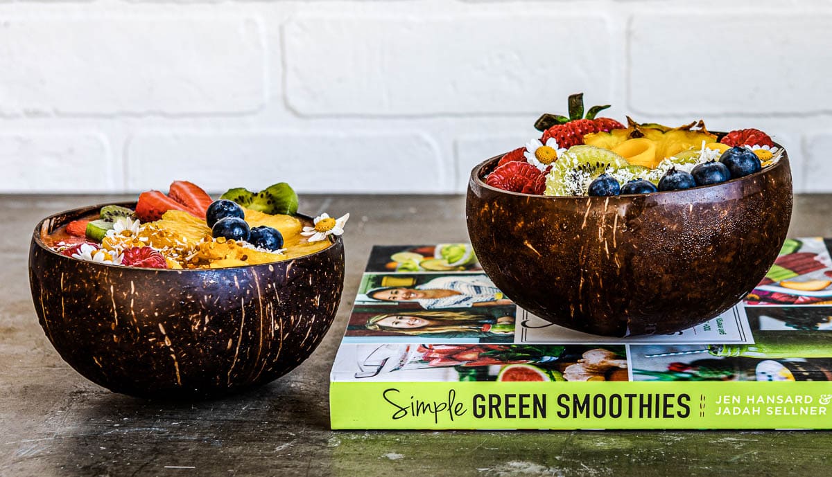 2 coconut smoothie bowls and a recipe book called Simple Green Smoothies.