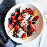 Vegan banana split on a plate with fresh berries