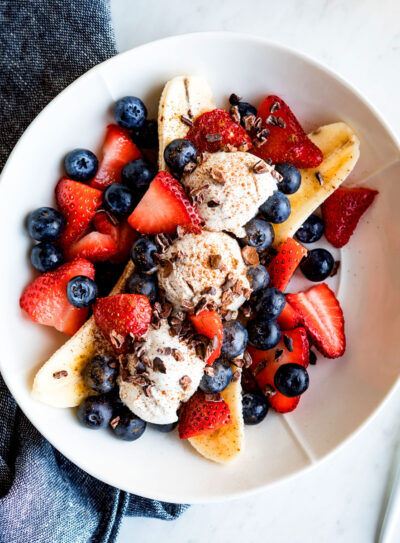 Vegan banana split on a plate with fresh berries