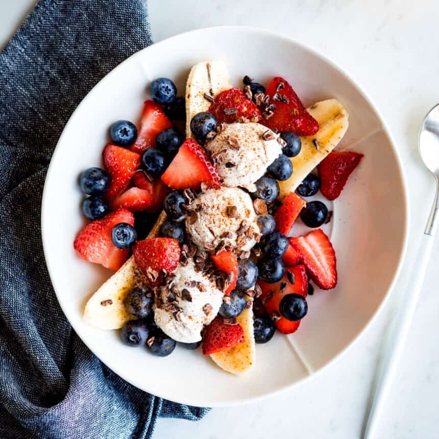 Vegan banana split on a plate with fresh berries