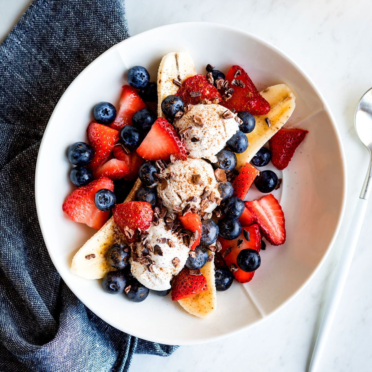 Vegan banana split on a plate with fresh berries