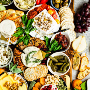 vegan charcuterie with plant based cheeses, fresh fruit, pickled veggies and an assortment of crackers.