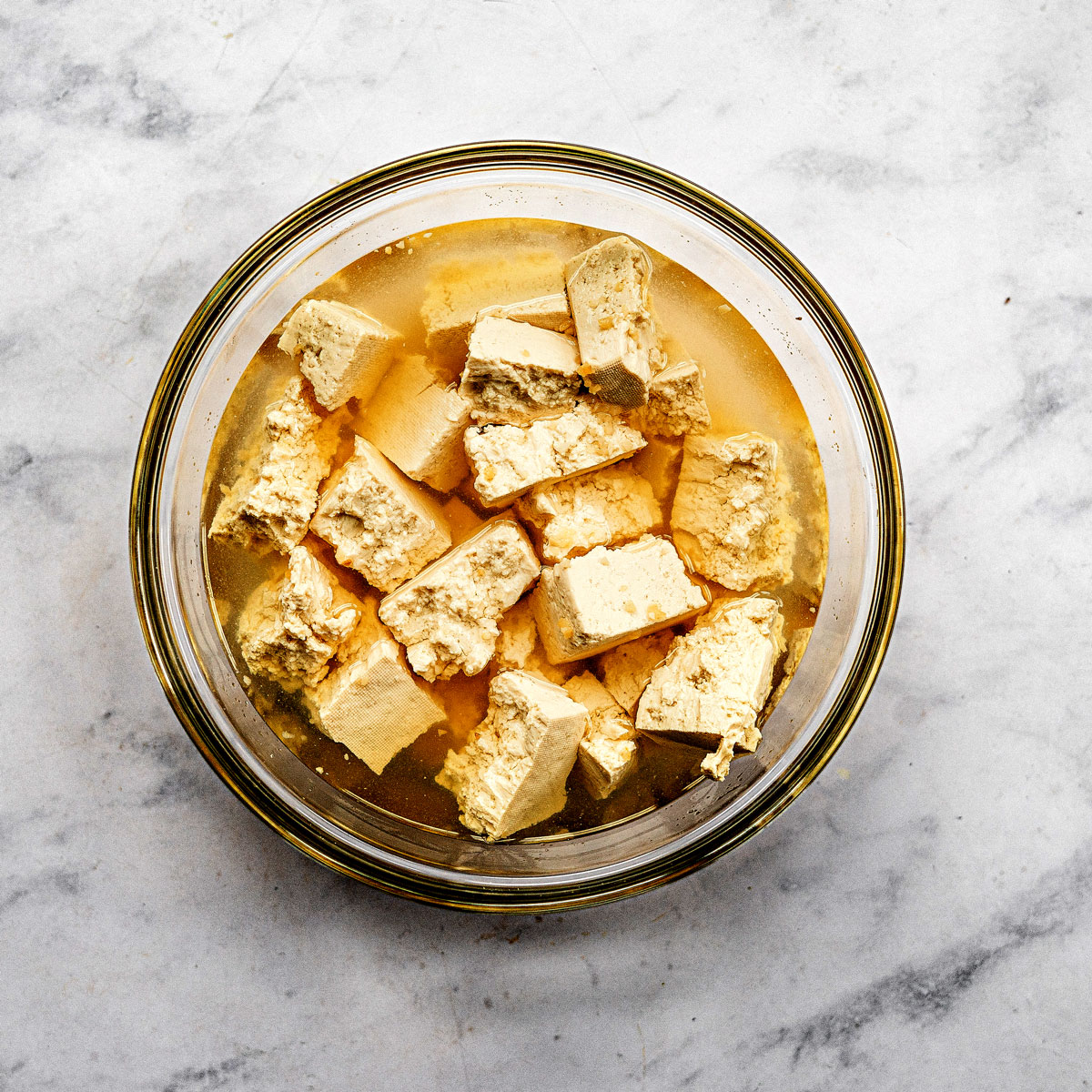 Tofu soaking in pickle brine to flavor the vegan chicken nuggets recipe.