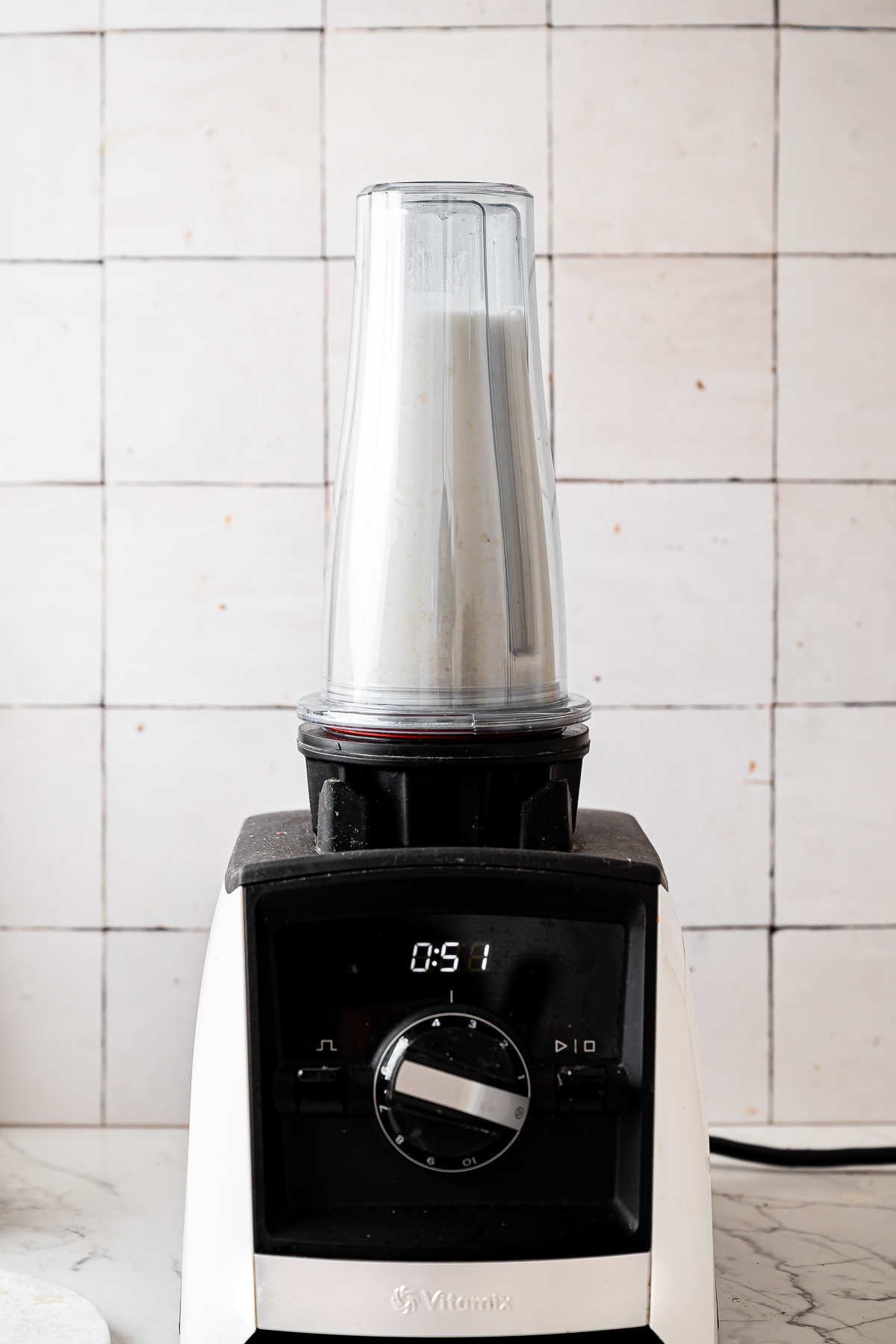 A blender mixing creamy coconut yogurt recipe ingredients