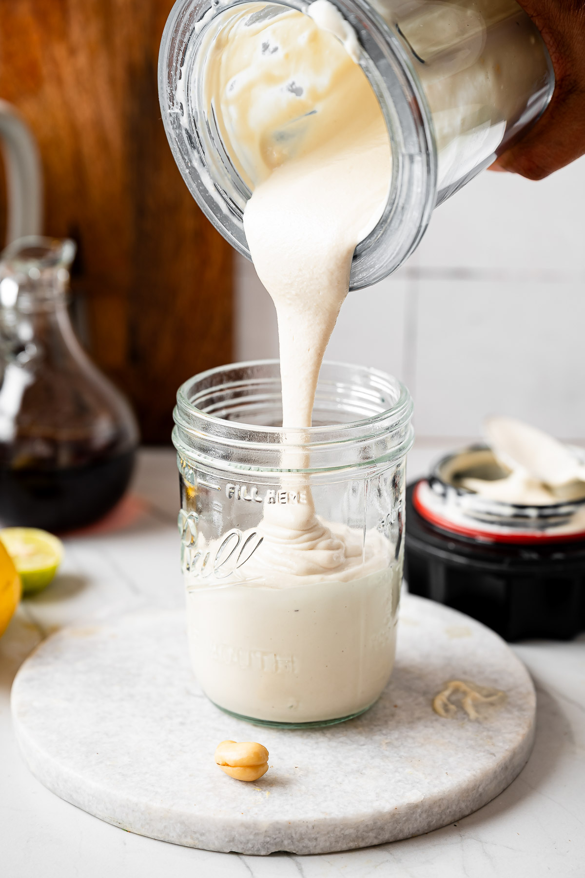 Pouring coconut yogurt into a jar for refrigeration