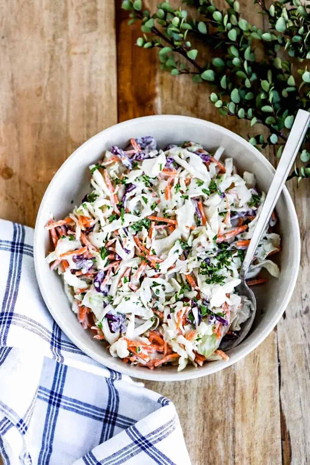 bowl on wood table with DIY dairy-free coleslaw