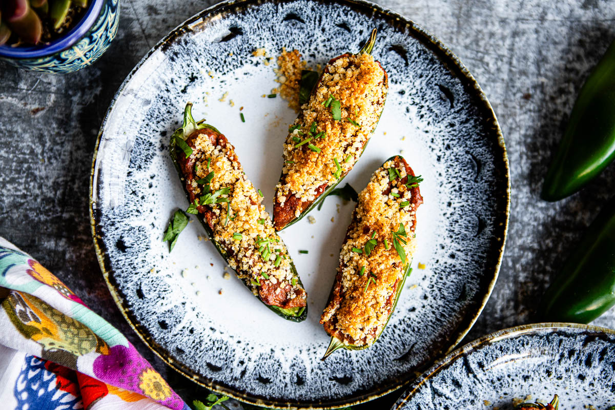 close up of three jalapeno peppers covered in breadcrumbs.