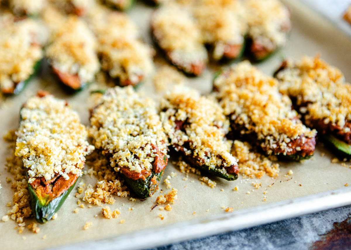 baking vegan jalapeno poppers in oven on parchment paper.