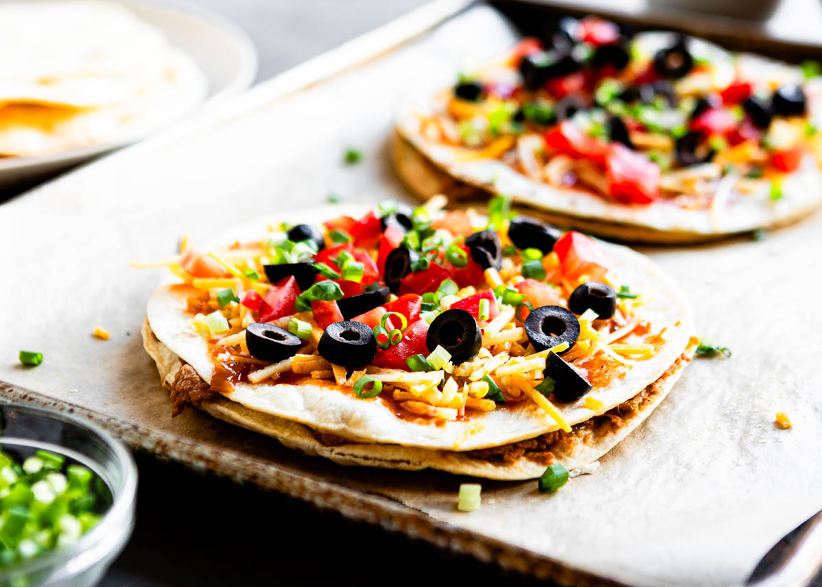 finished vegan Mexican Pizzas on a parchment lined baking sheet.