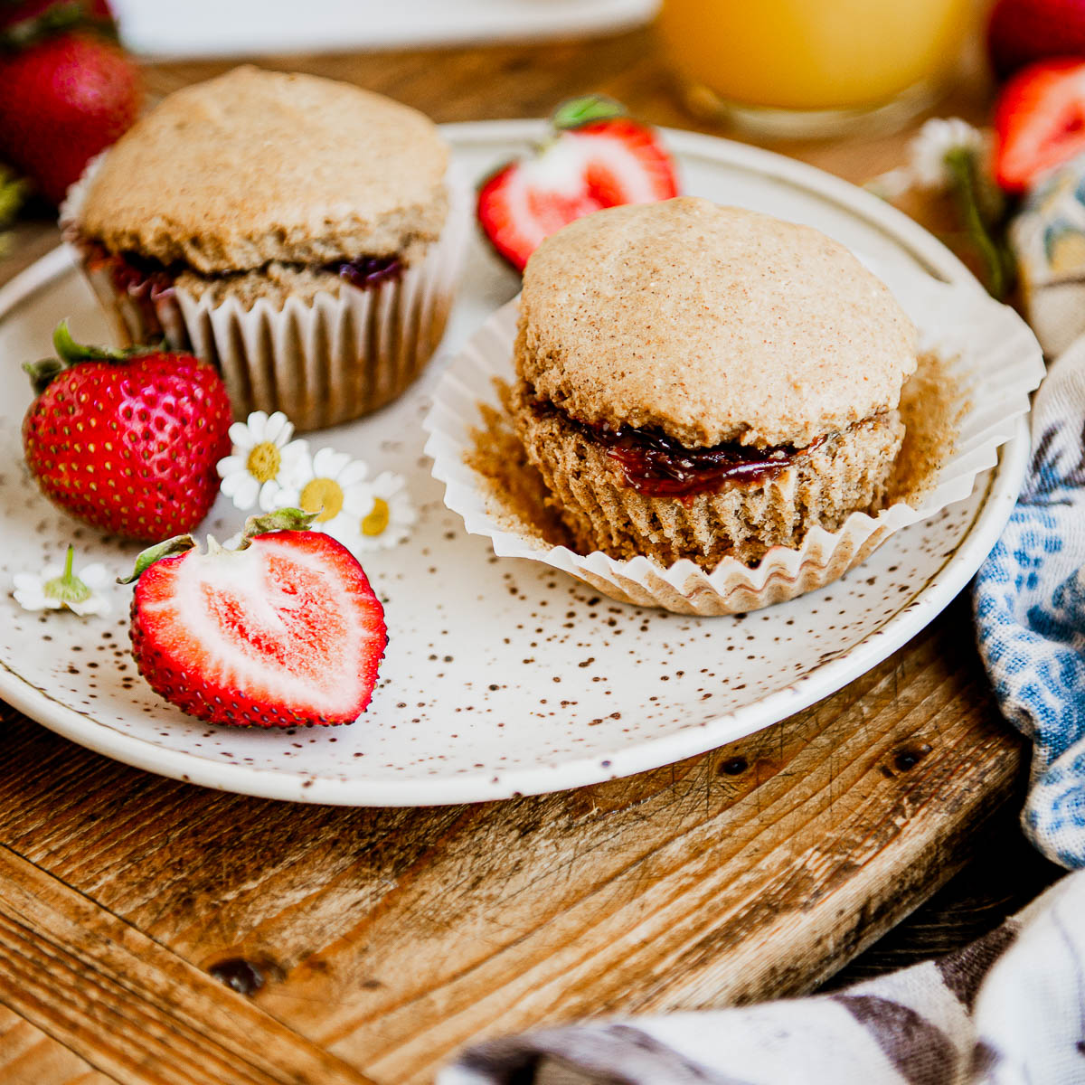 Two strawberry vegan muffins on a plate.