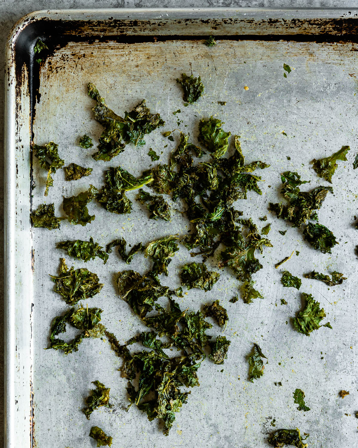 Crispy flakes of baked kale on a sheep pan 