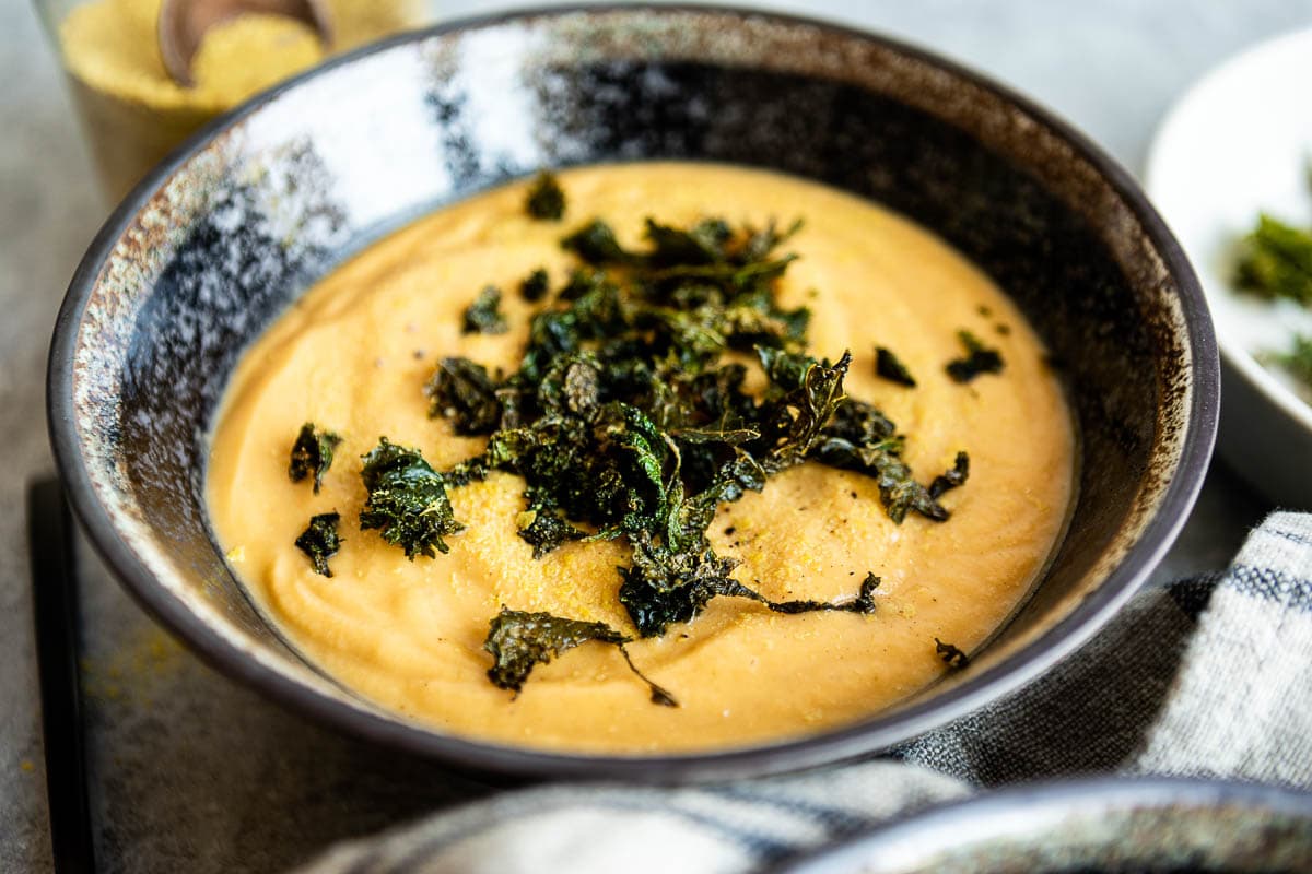 bowl of vegan potato soup topped with kale croutons.