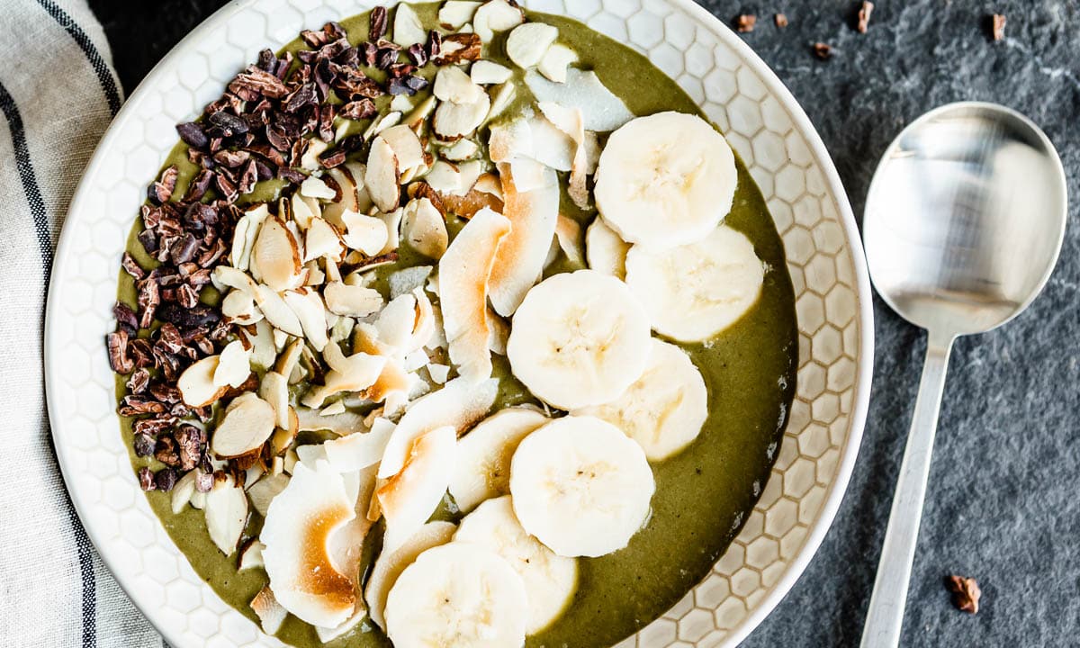 green smoothie bowl with a variety of toppings