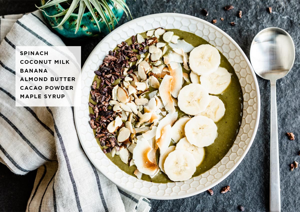 text over a photo of a vegan smoothie bowl showing ingredients needed including spinach, coconut milk, banana, almond butter, cacao powder and maple syrup