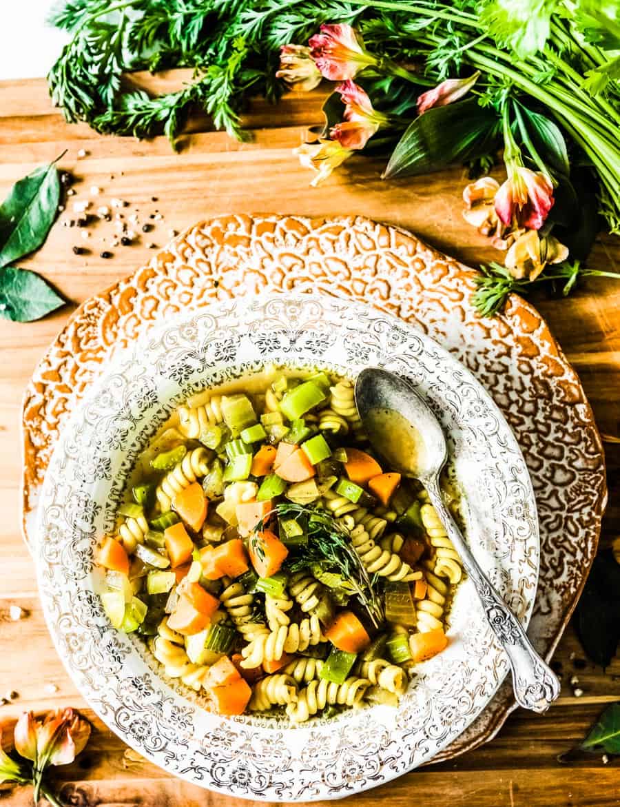 vegan chicken noodle soup in a festive bowl with an antique spoon.