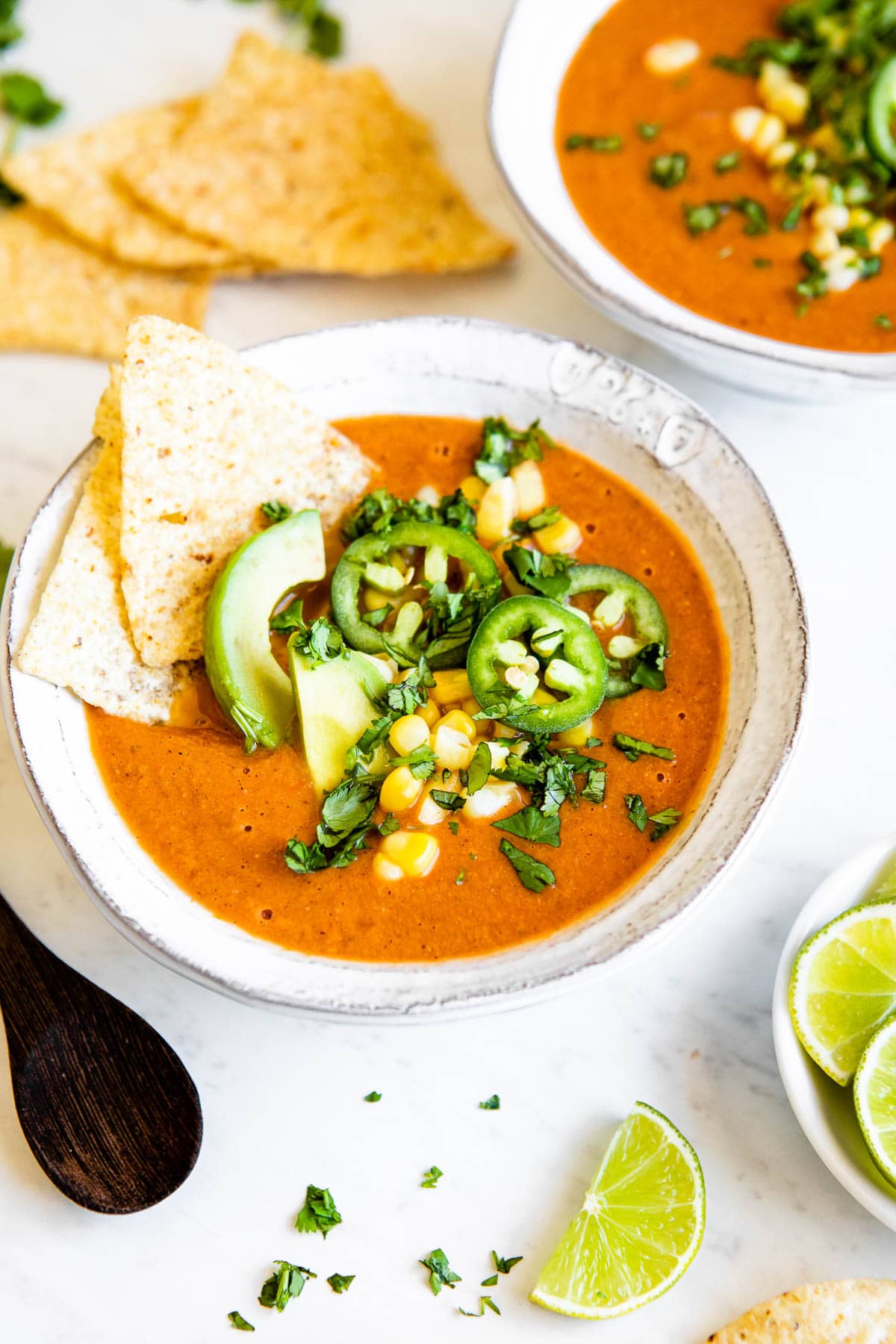 vegetarian tortilla soup topped with corn, jalapeños, avocado, cilantro and tortilla chips.