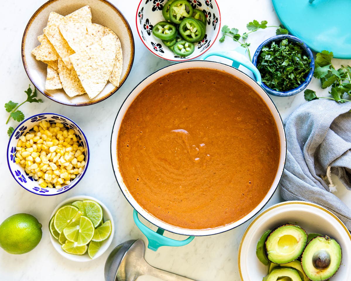 healthy tortilla soup recipe with bowls of toppings surrounding it