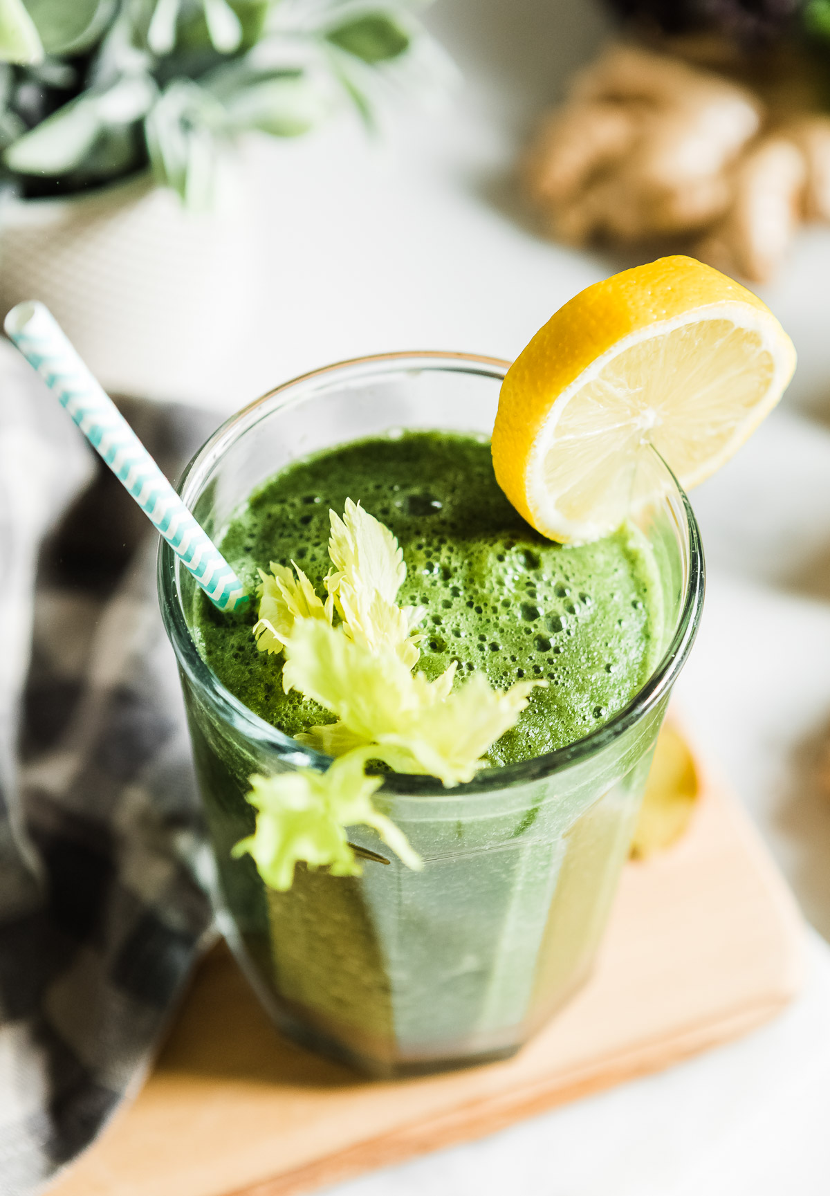 Veggie fruit smoothie topped with leafy greens and a lemon wheel, ready to drink