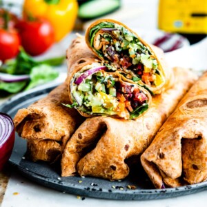 veggie wrap in sun-dried tomato tortilla on plate.