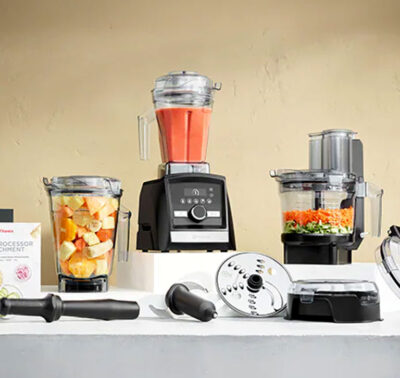 Blender, food processor and cookbook stacked on shelves with fresh fruit and veggies
