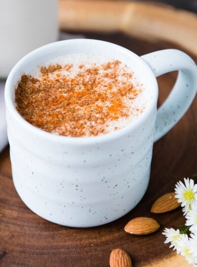 photo of warm almond milk topped with cinnamon in a white clay mug