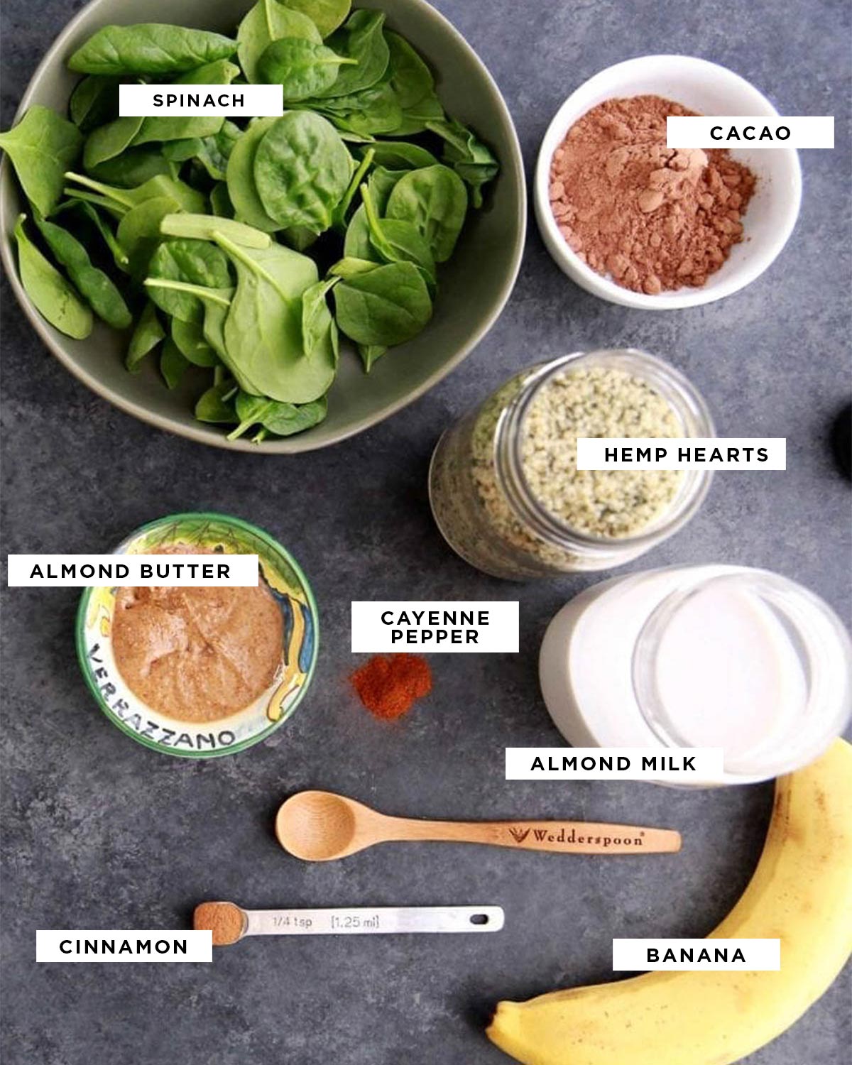 ingredients in black text surrounded by white boxes for a weight loss protein smoothie including spinach, cacao, hemp hearts, almond butter, cayenne pepper, almond milk, cinnamon and banana.