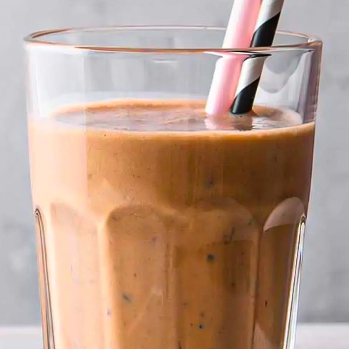 Two straws in a glass of chocolate weight loss shake.