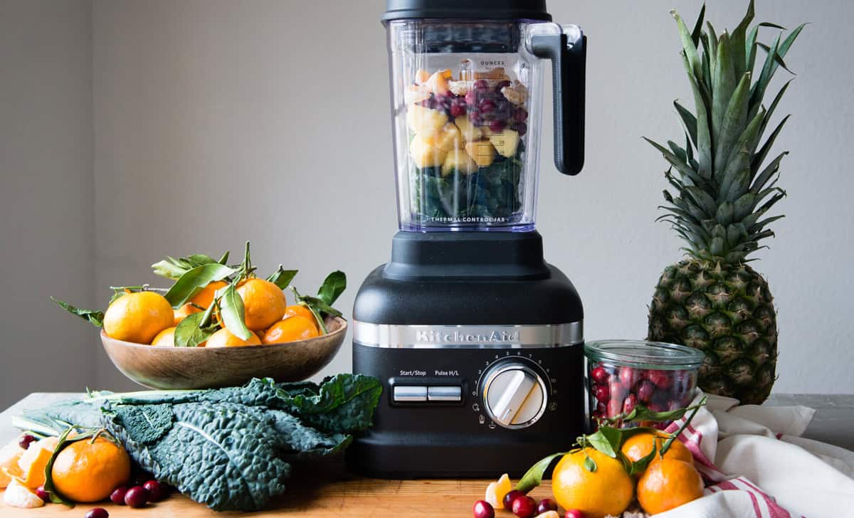 High-speed blender with fresh fruits and vegetables for smoothies.