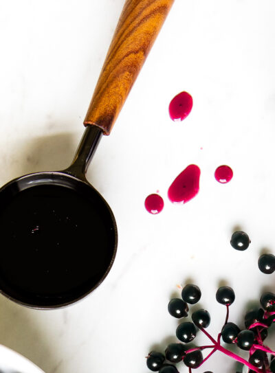 Elderberry syrup in wood and metal tablespoon