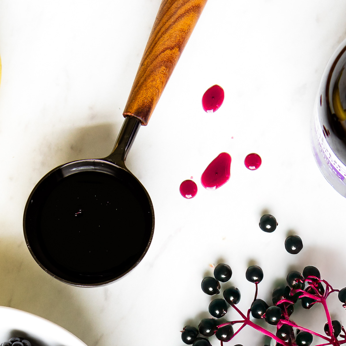 Elderberry syrup in wood and metal tablespoon