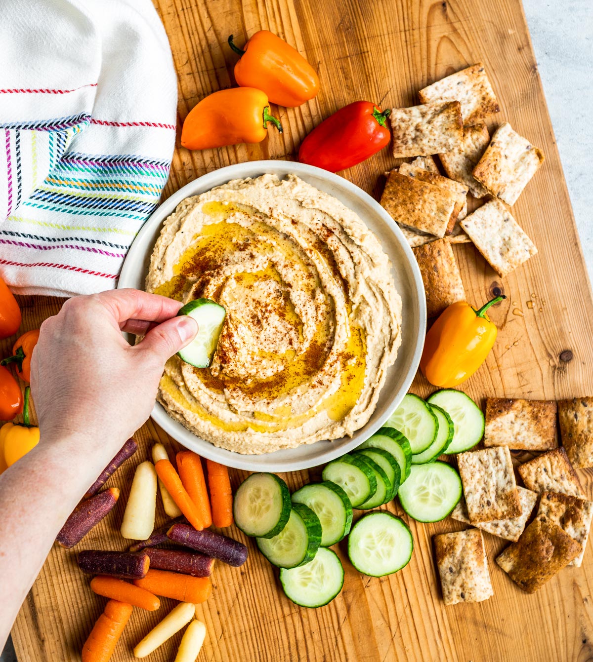 Serving homemade hummus with vegetables and crackers