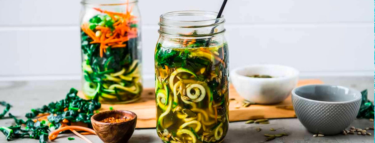 two jars of zucchini noodle soup with a variety of ingredients