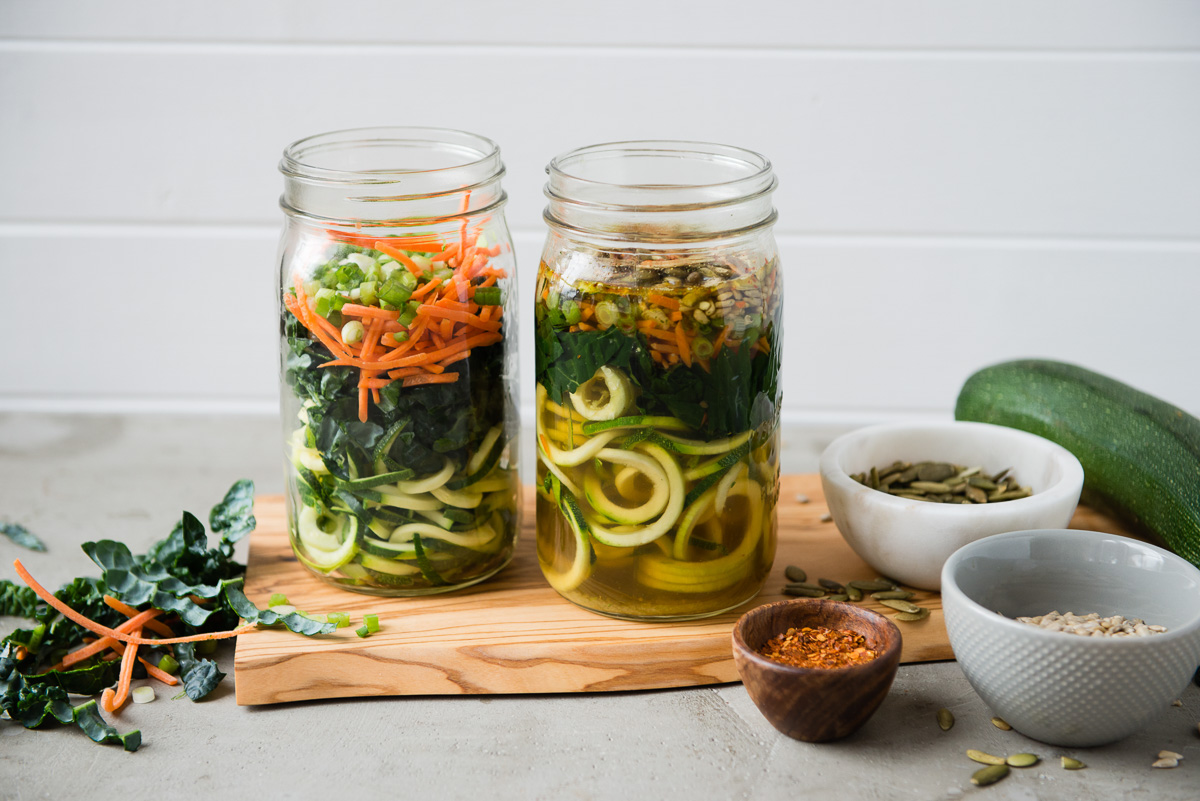 Zoodles and shredded carrots in mason jars.