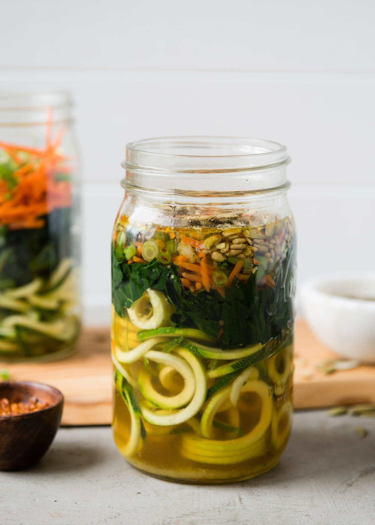 Large jar with spiralized zucchini noodles and vegetable broth.